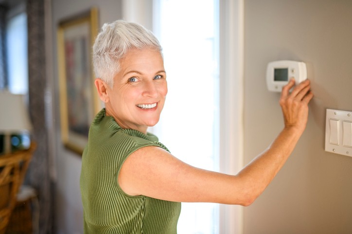 Home with thermostat showing reduced heating to save energy.